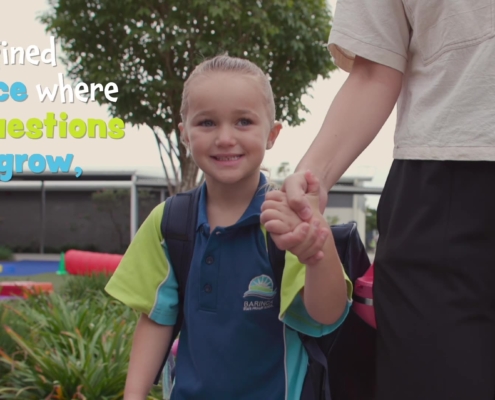 A Prep student holds her mum's hand walking to school